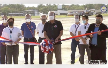 <p><span style="line-height: 1.5;"><strong>AIRPORT DEVELOPMENT</strong>. Transportation Secretary Arthur Tugade (center) leads the inauguration of the new taxiway of the Mactan-Cebu International Airport on Wednesday (May 5, 2021), along with Presidential Assistant for the Visayas Secretary Michael Lloyd Dino (left) and MCIA acting general manager Glenn Napuli (right). Tugade said the new taxiway is seen to boost the airport’s aircraft capacity and long-term development in Cebu. <em>(Screengrab from RTVM video)</em></span></p>