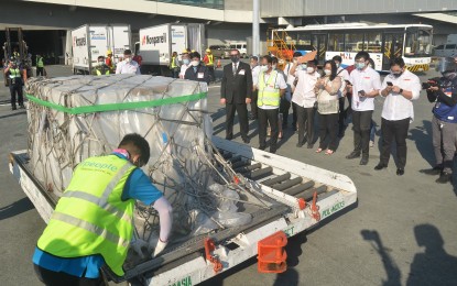 <p><strong>FIRST BATCH</strong>. Top national government officials and delegates look on as airport personnel unwraps the first shipment of Sputnik V Covid-19 vaccine that arrived at the NAIA Terminal 3 in Pasay City on Saturday (May 1, 2021). The first 15,000 doses of the Russian-made vaccine arrived on board a Qatar Airways flight from Moscow while the next batch of 485,000 doses is expected to be delivered within May. <em>(PNA photo by Robert Oswald P. Alfiler)</em></p>