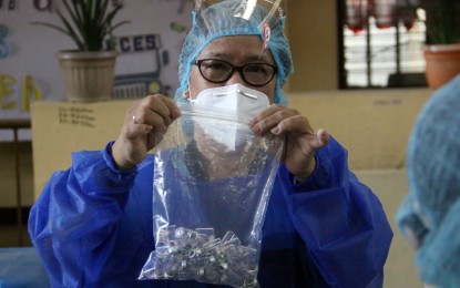 <p><strong>2ND SHOT.</strong> A healthcare worker shows empty vials of the CoronaVac jabs at Pedro P. Cruz Elementary School in Mandaluyong City on Wednesday (May 5, 2021). The recipients were those who availed of the first dose on April 7. <em>(PNA photo by Joey O. Razon)</em></p>
