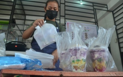 <p><strong>STAYING SAFE.</strong> A store personnel wearing a face mask prepares cups of <em>halo-halo</em> for delivery in Diliman, Quezon City on Thursday (May 6, 2021). Justice Secretary Menardo Guevarra said the President’s directive for law enforcers to arrest individuals not wearing face masks, a violation of public health protocols, takes effect immediately even without the guidelines. <em>(PNA photo by Robert Oswald P. Alfiler)</em></p>