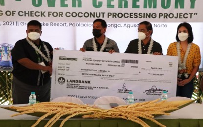 <p><strong>FUNDING FOR VCO PLANT.</strong> Philippine Coconut Authority (PCA) 13 (Caraga) manager, Joel B. Oclarit (left), hands over to Mayor Napoleon Montero (2nd from left) a replica of the PHP17 million check that will fund the construction of a virgin coconut oil processing plant in Jabonga, Agusan del Norte, on Thursday (May 6, 2021). Agusan del Norte 2nd District Rep. Maria Angelica Amante-Matba (right) and Governor Dale B. Corvera also attended the processing plant's groundbreaking on the same day. <em>(Photo courtesy of PCA-13)</em></p>