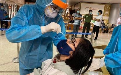 <p><strong>TEST.</strong> A health worker takes samples for Covid-19 tests at Tân Sơn Nhất Airport in Ho Chi Minh City, Vietnam in this February 2021 photo. The city wants to double its current daily testing capacity of 15,000. <em>(Photo courtesy of Đinh Hằng)</em></p>