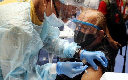 <p><strong>ON-THE-GO JABS.</strong> A health worker gives the Sputnik V vaccine to an elderly citizen at the Makati Coliseum on May 4, 2021. Makati Mayor Abby Binay said Tuesday (May 11, 2021) the city government’s drive-through Vaccination On-The-Go program would boost the city's capacity to inoculate residents. <em>(PNA photo by Jess M. Escaros Jr.)</em></p>