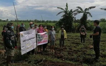<p><strong>NEW LANDOWNERS</strong>. Municipal Agrarian Reform Program Officer Drexel Glen Pajarilla leads the installation of 21 farmer-beneficiaries on 12.78 hectares of property formerly owned by Juan Yulo in Barangay Candumarao, Hinigaran, Negros Occidental on Tuesday (May 11, 2021). The installation was facilitated by the Department of Agrarian Reform-Negros Occidental II, which covers areas in the southern part of the province.<em> (Photo courtesy of DAR Negros Occidental II-South)</em></p>