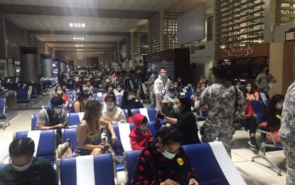 <p><strong>REPATRIATED</strong>. Filipinos repatriated from China waiting for instructions upon arrival at the NAIA Airport on May 14, 2021. This is the sixth flight chartered by the DFA for Filipino nationals stranded in China since the pandemic. (<em>Photo courtesy of DFA Philippines/OUMWA</em>) </p>