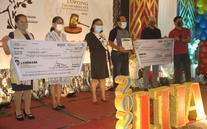 <p><strong>TOP LUPON CITED.</strong> DILG-13 Director Lilibeth A. Famacion (3rd from left), together with DILG Butuan Director Charissa T. Guerta (left) and City Administrator Reynaldo Desiata (2nd from right), awards cash prizes to Barangay Doongan Barangay Captain Gilberto Enriquez (3rd from right) during the Lupong Tagapamayapa Incentives Awards on Monday (May 17, 2021). Barangay Doongan receives PHP150,000 for the award. <em>(PNA photo by Alexander Lopez)</em></p>