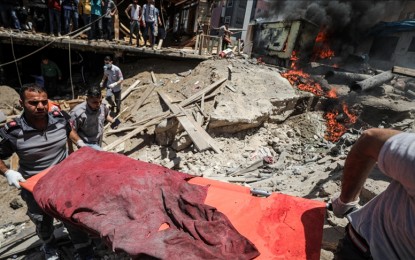 <p><strong>DEAD.</strong> A body covered in cloth is carried using a stretcher amid the rubbles resulting from Israeli airstrikes on Gaza. The Palestinian Health Ministry on Tuesday (May 18, 2021) placed the death toll at 213. <em>(Anadolu photo)</em></p>