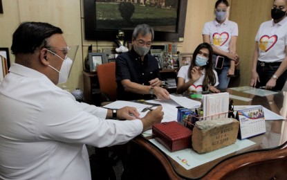 <p><strong>RESTORATION.</strong> Presidential Spokesperson Harry Roque (left) and Philippine General Hospital Director Dr. Gerardo Legaspi on Tuesday (May 18, 2021) discuss the restoration of some areas of the central block building damaged by fire on May 15, 2021. Also in photo are members of the Pitmaster Foundation that donated cash and an ambulance. <em>(PNA photo by Avito C. Dalan)</em></p>