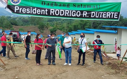<p><strong>PERMANENT HOUSING.</strong> National Housing Authority General Manager Marcelino Escalada Jr. (2nd from L) leads the ribbon-cutting during the turnover of the 240 permanent housing units for the victims of the earthquake in Magsaysay, Davao del Sur, on Monday (May 17, 2021). With him are Mayor Arthur Davin (4th from right), Vice Mayor Donnabel Joy Mejia (leftmost), and NHA-11 Acting Manager Sonia Bulseco (2nd from right). <em>(Photo courtesy of NHA-11)</em></p>