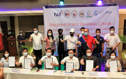 <p><strong>LAND DONATION</strong>. Sports officials and local government leaders of Bataan pose for photo opportunity after the ceremonial signing and turnover of the deed of donation for the land donated by Bataan for the site of the Philippine Sports Training Center at The Orient Bataan in Mariveles, Bataan on Tuesday (May 18, 2021). Senator Christopher “Bong” Go (seated 3rd from right) joined the Philippine Sports Commission officials led by chairman William Ramirez (2nd from left) and Bataan Governor Albert Garcia (4th from left). <em>(Photo courtesy of PSC)</em></p>