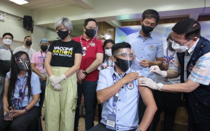 <p><strong>SYMBOLIC INOCULATION.</strong> Health Secretary Francisco Duque III (right) administers the Sinovac Covid-19 vaccine to an employee of Universidad de Manila on Tuesday (May 18, 2021). Manila Vice Mayor Honey Lacuna and City Health Officer Dr. Arnold Pangan (1st and 3rd from left) witness the event held as part of the Commission on Higher Education’s 27th founding anniversary week.  <em>(PNA photo by Avito C. Dalan)</em></p>