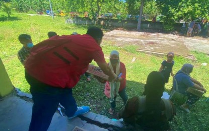 <p><strong>EXTENDING HELP.</strong> A social worker hands over a food pack to one of the workers of the La Frutera banana plantation in Datu Paglas, Maguindanao, on Tuesday (May 18, 2021) as part of DSWD’s Technical Assistance and Resource Augmentation program initiated under the Office of the President. At least 976 banana plantation workers benefited from the aid, in coordination with the BARMM Ministry of Social Services and Development. <em>(Photo courtesy of DSWD-12)</em></p>