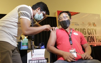 <p><strong>FIRST DOSE.</strong> A man gets his first dose of Sinovac vaccine in Taguig City. Secretary Carlito Galvez Jr., National Task Force Against Covid-19 chief implementer said the Philippines is now the leader among five of the biggest Asean countries in terms of vaccine throughput per capita with an average daily vaccination rate of 150,000 jabs. <em>(PNA photo by Avito C. Dalan)</em></p>