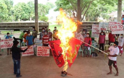 <p><strong>PULLING OUT THEIR SUPPORT</strong>. Residents of Barangay Minapasuk in Calatrava, Negros Occidental burn the flags of the Communist Party of the Philippines-New People’s Army during a condemnation rally held at the village covered court on Wednesday (May 19, 2021). The villagers said they have been victims of the exploitation of the communist-terrorist group and denounced them as purveyors of useless and meaningless ideology. <em>(Photo courtesy of 79th Infantry Battalion, Philippine Army)</em></p>