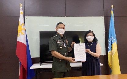 <p><strong>CASES OF WILLFUL KILLINGS</strong>. Human Rights Commissioner Karen Dumpit (right) receives from Brig. Gen. Jose Alejandro S. Nacnac, Director of the Armed Forces of the Philippines Center for the Law on Armed Conflict (AFPCLOAC) on May 20, 2021, the report on willful killings committed by the CPP-NPA-NDF from 2010 to 2020. (<em>AFPCLOAC photo</em>)</p>
<p> </p>