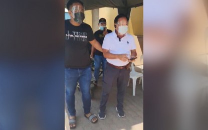 <p><strong>ARRESTED.</strong> Authorities arrest Tarlac City task force quarry head Pedro Soliman II (right) in an entrapment operation for alleged extortion activities at the Tarlac City Hall on Monday (May 24, 2021). A complainant was allegedly asked by Soliman to pay PHP240,000 in exchange for her quarry clearance. <em>(Contributed photo)</em></p>