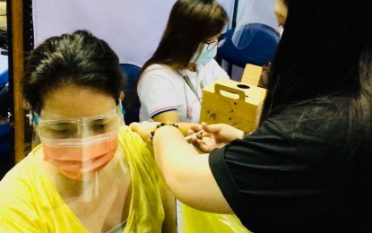 <p><strong>FIRST SHOT.</strong> A woman with comorbidity receives her first dose of AstraZeneca vaccine in Quezon City. A health official said less than one percent of the persons who received the Covid-19 vaccine experienced serious adverse events. <em>(File photo)</em></p>