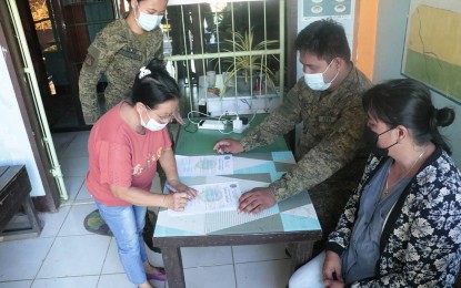 <p><strong>GRIEVING MOTHER.</strong> Marina Borres (2nd from left) signs documents to claim the remains of her son, Cris Guilayon, a New People’s Army (NPA) combatant killed in an encounter on May 20, 2021 in Barangay Guinabsan, Buenavista, Agusan del Norte. Borres was assisted by 2Lt. Angel Grace M. Sebelina (1st from left), the acting civil-military operations officer of the Army's 23rd Infantry Battalion. <em>(Photo courtesy of 23IB)</em></p>