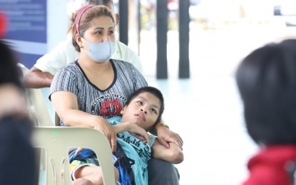 <p><strong>HOPEFUL.</strong> Virginia Cruz and her six children, including 17-year-old Cedrick who has disabilities, wait for further instructions at the Balik Probinsya, Bagong Pag-Asa Program depot in Quezon City on Thursday (May 27, 2021). Once her Covid-19 test turns out negative, they will fly home to Leyte on Friday morning. <em>(Photo by Robert Alfiler)</em></p>