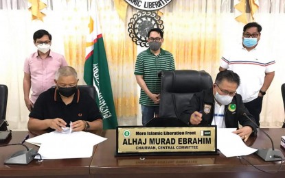 <p><strong>HUGE WATER PROJECT.</strong> BARMM Chief Minister Ahod Murad Ebrahim (right) signs the memorandum of agreement on Sunday (May 30, 2021) with Lanao del Sur Governor Mamintal Adiong Jr. (left) for the expansion of the water system project in Marawi City. Looking on are other BARMM officials. <em>(Photo courtesy of BARMM Interior Minister Naguib Sinarimbo)</em></p>