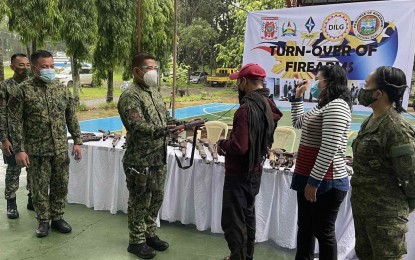 <p><strong>BACK TO THE GOV'T FOLD</strong>. Officials of the Army's 8th Infantry Battalion receive a firearm from one of the 18 former rebels during a turnover ceremony at the Camp Cpt. Ramon M. Onahon, Provincial Headquarters, Malaybalay City, Bukidnon on TUesday (June 1, 2021). The rebels will receive cash incentives as part of the Enhanced Comprehensive Local Integration. (<em>Photo courtesy of 8IB</em>) </p>