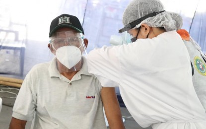 <p><strong>VACCINATED</strong>. A health professional administers vaccination for Covid-19 to a senior citizen at the Imelda Cultural Center in Batac City, Ilocos Norte. He is among the 11,186 individuals in Ilocos Norte who got their first shot of the AstraZeneca vaccine last month. (<em>Photo courtesy of the City Government of Batac</em>) </p>