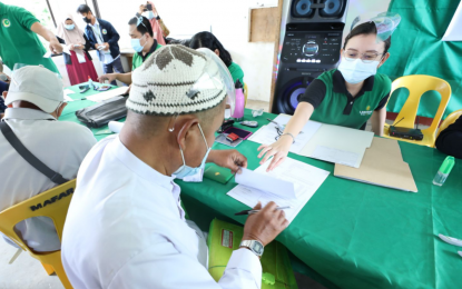 <p><strong>ZERO-INTEREST LOAN.</strong> A female representative of the Land Bank of the Philippines assists a farmer in Marawi City on May 28, 2021, fill up his form for an interest-free cash loan of PHP25,000 payable within the next 10 years. A total of 80 farmers from Lanao del Sur province received the loan assistance as facilitated by the Ministry of Agriculture, Fisheries and Agrarian Reform-Bangsamoro Autonomous Region in Muslim Mindanao. <em>(Photo courtesy of MAFAR-BARMM)</em></p>