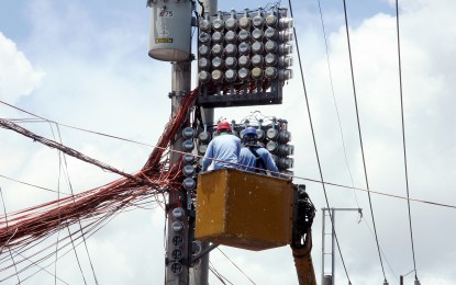<p><strong>METER CHECK.</strong> Manila Electric Company linemen inspect meters and a power transformer on a concrete post along Cogeo Avenue, Antipolo City on May 29, 2021. Some parts of Luzon experienced rotational power interruptions from May 31 until June 2. <em>(PNA photo by Joey O. Razon)</em></p>