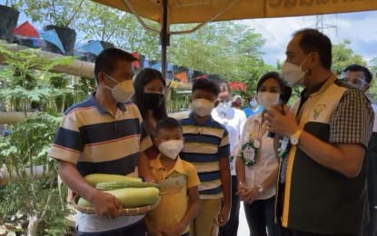 <p><span style="line-height: 1.5;"><strong>FOOD SECURITY PROGRAM</strong>. Agriculture Secretary William Dar (right) talks with an urban gardener in Mandaue City on Thursday (June 3, 2021) as Governor Gwendolyn Garcia (second from right) looks on. During his visit in Cebu, Dar assured the province of the agency's continued support for its food security initiative, the Sugbusog Program<em>. (Screengrab from Cebu Capitol PIO live video)</em></span></p>