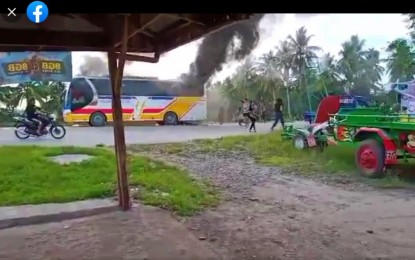 <p><strong>BUS ON FIRE</strong>. Black smoke rises from a burning YBL bus torched by a passenger while it was traveling to M’lang, North Cotabato on Thursday afternoon. Three unidentified passengers perished in incident suspected to be the handiwork of Al Khobar extortion group. <em>(Photo courtesy of DXND Kidapawan)</em></p>