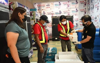 <p><strong>MORE VACCINE SUPPLY</strong>. Dr. Edwin Miraflor Jr. (right), officer-in-charge of the City Health Office, receives the additional 10,000 vials of Sinovac’s CoronaVac jabs that arrived in Bacolod City on Saturday (June 5, 2021). The supply was immediately stored at the CHO’s cold room facility beside the Government Center.<em> (Photo courtesy of Bacolod City PIO)</em></p>