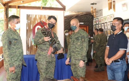 <p><strong>GAINING HEADWAY</strong>. The campaign against the proliferation of loose firearms continues to gain headway as two more Basilan towns express support on Thursday (June 3, 2021). Photo shows Maj. Gen. Bartolome Vicente Bacarro, 2nd Infantry Division command (2nd from left), inspecting one of the loose firearms surrendered during the signing of a memorandum of understanding at the headquarters of the 68th Infantry Battalion in Lamitan City, Basilan. <em>(Photo courtesy of the Joint Task Force Basilan)</em></p>