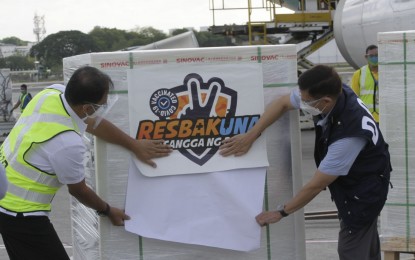 <p><strong>1 MILLION MORE DOSES.</strong> Vaccine czar Secretary Carlito Galvez (left) and Health Secretary Francisco Duque III (right) place "Resbakuna, Kasangga ang Bida" sticker on the cargo boxes containing 1 million Sinovac’ CoronaVac vaccines that arrived on board Cebu Pacific flight 5J671 at the Ninoy Aquino International Airport in Pasay City on Sunday (June 6, 2021). Galvez said the majority of the vaccines will be distributed in Visayas and Mindanao areas with high Covid-19 cases. <em>(PNA photo by Avito C. Dalan)</em></p>
