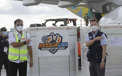<p><strong>VAX ARRIVAL</strong>. National Task Force Against Covid-19 head Secretary Carlito Galvez Jr. (left) and Health Secretary Francisco Duque III welcome 1 million doses of Sinovac vaccines at the Ninoy Aquino International Airport Terminal 2 in Pasay City on Sunday (June 6, 2021). Galvez said the country will receive over 11 million doses of vaccine this month of June. <em>(PNA photo by Avito C. Dalan)</em></p>