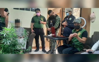 <p><strong>'PLANTITO' FALLS.</strong> Hussein Muaad Hasan also known as “Muath Yaf” (seated left), a Yemeni national, is facing drug charges for growing marijuana plants during a search warrant operation in his house in Bakakeng Central in Baguio City on June 5, 2021. The search yielded three fully grown marijuana plants in pots. <em>(Photo courtesy of PROCOR-PIO)</em></p>