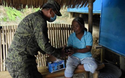 <p><strong>RADIO SET</strong>. A trooper of the Philippine Army’s 14th Civil-Military Operations Battalion Special Enabler Company gives a transistor radio to a resident of Barangay Linaon, Cauayan town in Negros Occidental on Monday (June 7, 2021). The unit installed a portable FM transmitter for the Voice of Peace 100.1 FM Radio to support their Community Support Program operations in the village.<em> (Photo courtesy of 14th CMO Battalion, Philippine Army)</em></p>