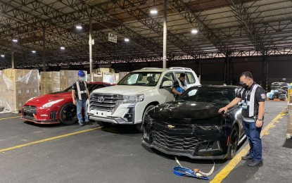 <p><strong>MORE 'HOT CARS'.</strong> Customs officers inspect three smuggled luxury cars that were intercepted at the Manila International Container Port (MICP) on Wednesday (June 9, 2021). BOC officers earlier intercepted smuggled luxury cars in separate operations at the port on May 26 and June 2. <em>(Photo courtesy of BOC-MICP)</em></p>