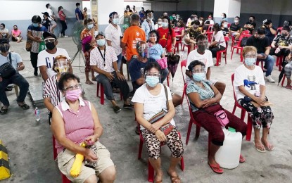 <p><strong>WAITING FOR JABS.</strong> Caloocan City residents wait for their turn to get the Sinovac Covid-19 vaccine at the parking area of a mall in Bagong Silang-Kanan on June 9, 2021. The Philippines started vaccinating economic front-liners and uniformed personnel on June 7. <em>(PNA photo by Ben Briones)</em></p>