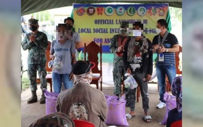 <p><strong>INTEGRATION PROGRAM</strong>. The Marine Battalion Landing Team-7 (MBLT-7) together with the Municipal Task Force to End Local Armed Conflict (MTF-ELAC) of Kalingalan Caluang, Sulu, launches a Local Social Integration Program (LSIP) to encourage former Abu Sayyaf Group members to embrace and new and productive life on Monday (June 14, 2021). In photo are the two of the former ASG bandits, who are beneficiaries of the program, receiving food assistance during the launching. <em>(Photo courtesy of MBLT-7)</em></p>