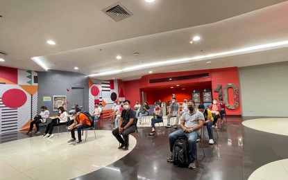 <p><strong>WAITING.</strong> Vaccine recipients belonging to the A4 category, or economic front-liners, wait at the cinema lobby of a mall in Manila on Thursday (June 17, 2021). Manila has been vaccinating as many as 2,500 daily in each of the four malls, with some workers saying they lined up the night before to make the cutoff. <em>(Photo courtesy of Manila-PIO)</em></p>