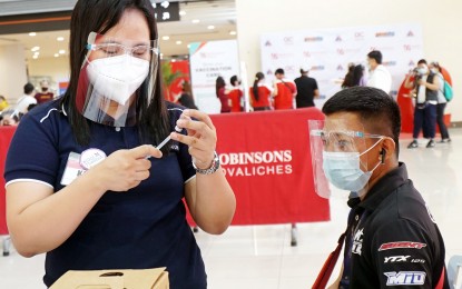 <p><strong>READY FOR VAX.</strong> Nurse Kaye Tejepo (left) prepares to administer a Sinovac Covid-19 vaccine at Robinsons Place Novaliches in Quezon City on Friday (June 18, 2021). The government aims to inoculate up to 70 million this year. <em>(PNA photo by Ben Briones)</em></p>