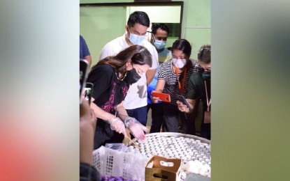<p><strong>LOCAL TOURISM</strong>. Tourism Secretary Bernadette Romulo-Puyat (left) tries one of the processes of making puto (rice cake), a well-known product of Calasiao town in Pangasinan on June 20, 2021. Puyat was joined by Calasiao town Mayor Mark Joseph Bauzon (fourth from right).<em> (Photo courtesy of Gerard Quinit)</em></p>