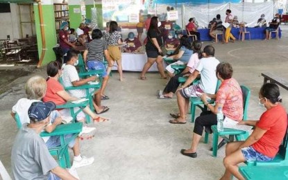 <p><strong>VACCINATION HUB</strong>. Residents of Barangay Tangub in Bacolod City line up to get vaccinated against Covid-19 at the covered gym of Villa Esperanza Elementary School on Tuesday (June 22, 2021). It is one of the 26 vaccination sites in identified barangays and clustered areas set up until June 23 for the rollout of 17,000 doses of Sinovac’s CoronaVac jabs deployed by the national government on June 5 and 8. <em>(Photo courtesy of Bacolod City PIO)</em></p>