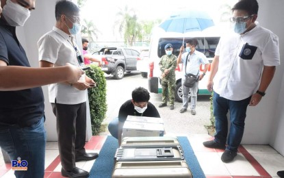 <p><strong>PFIZER VAX.</strong> Mayor Marc Brian Lim (right) looks at the Pfizer coronavirus disease 2019 (Covid-19) vaccines. The vaccines arrived in Dagupan City on June 21, 2021. <em>(Photo courtesy of Dagupan City Public Information Office)</em></p>