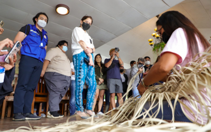 <p style="font-weight: 400;">Tourism Secretary Bernadette Romulo-Puyat watches a live weaving demo during her inspection of the Bolinao Sungayan Grill River Restaurant on June 21. <em>(DOT photo)</em></p>