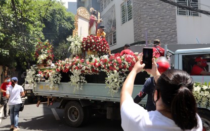 <p><strong>FEAST OF ST. JOHN THE BAPTIST</strong>. A woman takes a video during the motorcade of San Juan City's patron saint, St. John the Baptist, along A. Luna Street in San Juan City on June 24, 2020. This year's traditional splashing of water along the city streets is prohibited by the local government due to the Covid-19 pandemic. <em>(PNA file photo by Joey O. Razon)</em></p>