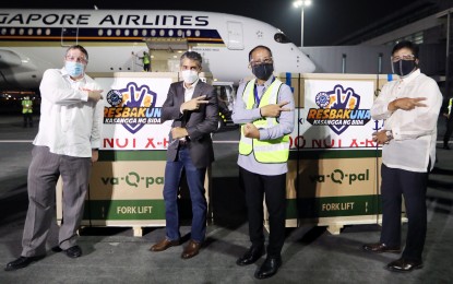 <p><strong>MODERNA IN PH.</strong> National Task Force Against Covid-19 chief implementer Secretary Carlito Galvez Jr. (2nd from right), Economic Counselor for US Embassy-Manila David Gamble Jr. (left) and International Container Terminal Services, Inc. (ICTSI) Executive Vice President Christian Razon Gonzalez (2nd from left) flash the Resbakuna sign during the arrival of Moderna vaccine at the NAIA Terminal 3 Pasay City on Sunday (June 27, 2021). This was the first delivery of 249,600 doses of the US-made vaccine. <em>(PNA photo by Joey O. Razon)</em></p>