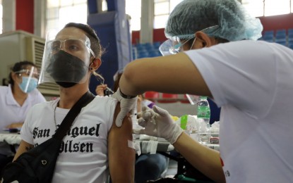 <p><strong>VIRUS PROTECTION.</strong> A health care worker carefully injects the Covid-19 jab on a resident at the Valenzuela Astrodome on Sunday (June 28, 2021). The city was also the site of Monday’s special inoculation activity to mark the country breaching the 10-million mark in jabs administered. <em>(PNA photo by Joey Razon)</em></p>