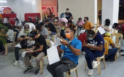 <p><strong>VACCINATION HUB</strong>. Residents of Bacolod City fill out the vaccination information form before availing of the Covid-19 vaccine at the inoculation center located at Robinsons Place Bacolod on June 30, 2021. The city has administered a total of 64,513 doses of vaccines to residents from March 5 up to June 30.<em> (Photo courtesy of Bacolod City PIO)</em></p>