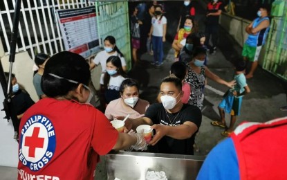 <p><strong>MEALS ON WHEELS.</strong> The Philippine Red Cross serves ready-to-eat hot meals to 239 persons from 50 families at San Gregorio Integrated School evacuation center in Laurel, Batangas on Friday (July 2, 2021). The agency also sent two ambulance units to the province. <em>(Photo courtesy of PRC Facebook)</em></p>
